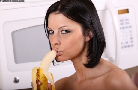 Older brunette lady Michelle flaunting round boobs while eating a banana