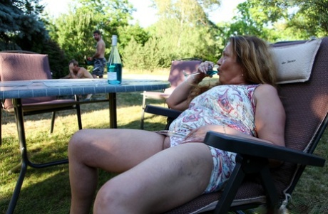 Horny mature with big juggs enjoys two young dongs in the back yard