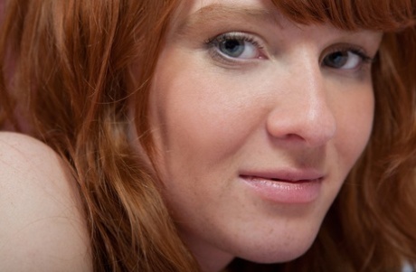 Sweet redhead with a hairy pussy Brisa poses naked in her bedroom