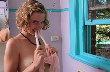 Curly-haired babe Kara Dasha licks her boobs and spreads her pussy
